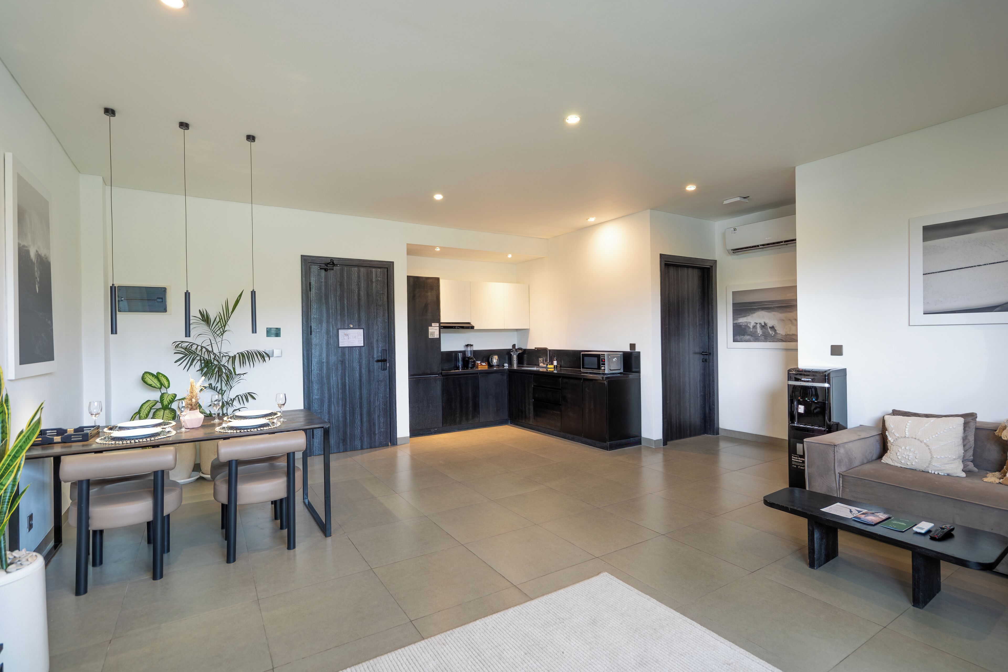 A modern living room with a dining area, kitchen, and a sofa.