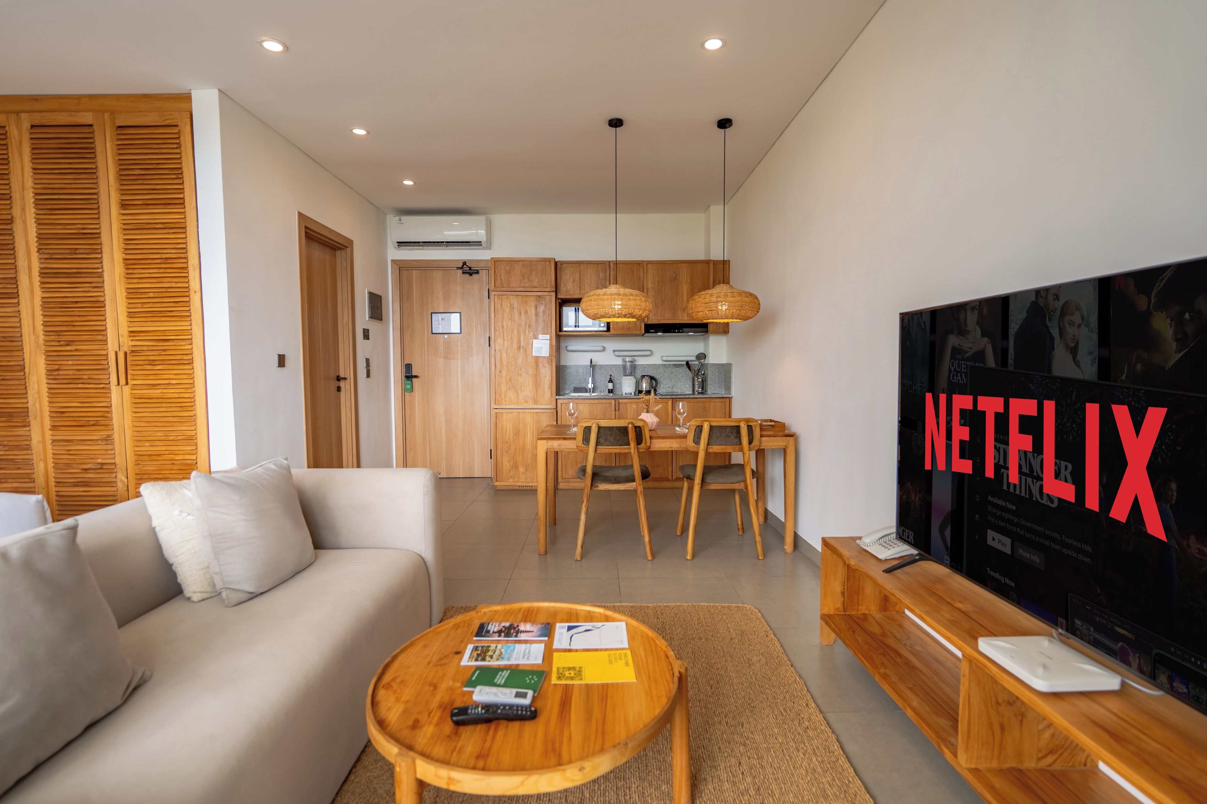 A modern living room with a sofa, coffee table, and a TV displaying the Netflix logo.
