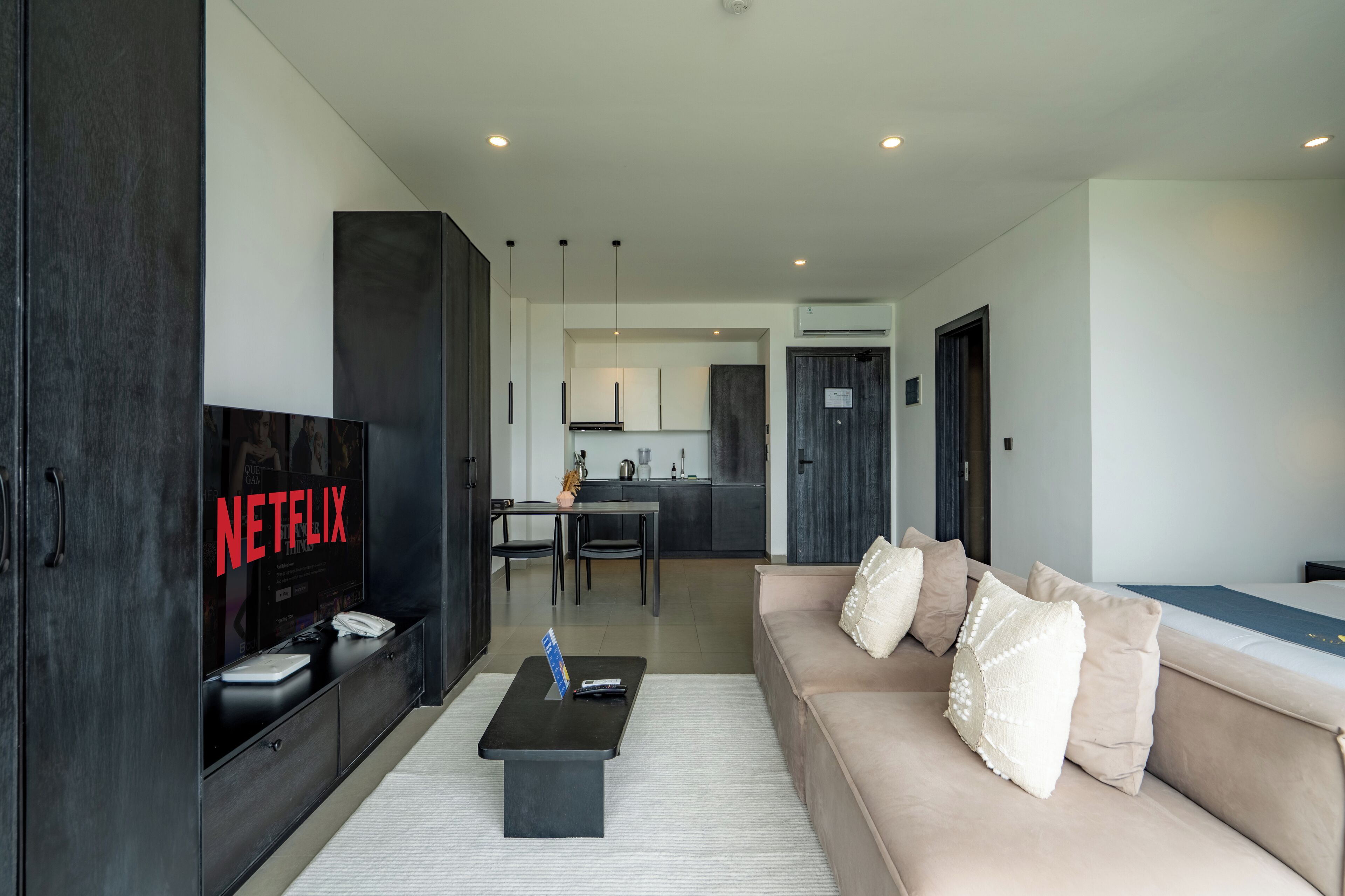 A modern living room with a sofa, a coffee table, and a TV displaying 'NETFLIX'.