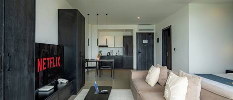 A modern living room with a sofa, a coffee table, and a TV displaying 'NETFLIX'.