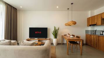 Suite Confort, balcón | Área de sala de estar | Smart TV de 65 pulgadas con canales digitales