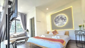 A modern hotel room with a bed, a bedside table, a shower area, and a view of the outdoors. - XOAI BIEN HOMESTAY PHAN THIET GAN BIEN (Phu Thuy)