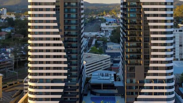 A modern building with a unique architectural design, featuring two symmetrical towers with balconies.