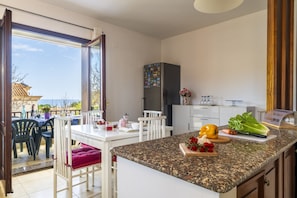 Eine Küche mit einer Granit-Arbeitsplatte, weißen Schränken und Blick ins Freie.