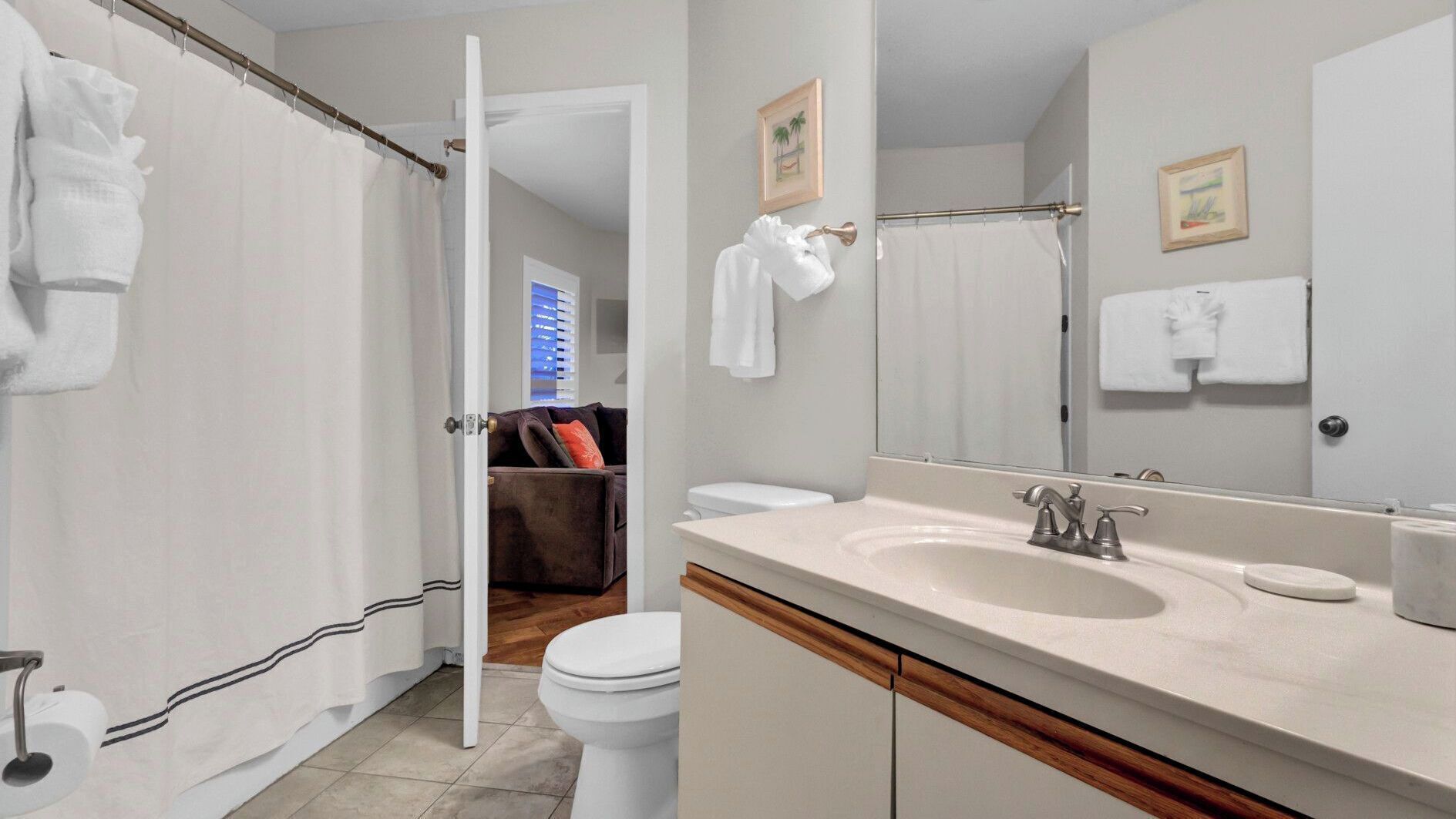 Une salle de bain avec des toilettes, un lavabo et un rideau de douche.
