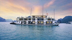 A large, multi-deck river cruise ship with a covered upper deck and multiple levels. - Mila Lux Cruise  (Tuan Chau)