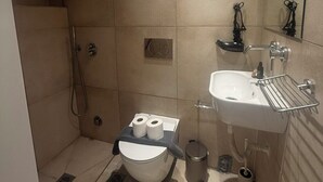Ein modernes Badezimmer mit Dusche, Toilette, Waschbecken und Spiegel.