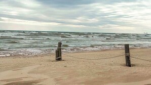 En strand med et træhegn og en rebstang.