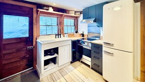 Eine kompakte Küche mit Backofen, Kühlschrank und Spüle.
