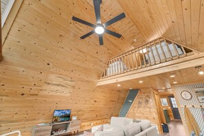 A wooden interior with a ceiling fan, a sofa, a TV, and a staircase. - LAKESIDE DOCKSIDE: Henrys Fork Private Beach Dock Fishing Yellowstone UTV Snowmobile Trails (Island Park)