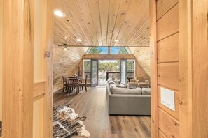 A wooden interior with a sofa, dining table, chairs, and a cowhide rug. - LAKESIDE DOCKSIDE: Henrys Fork Private Beach Dock Fishing Yellowstone UTV Snowmobile Trails (Island Park)
