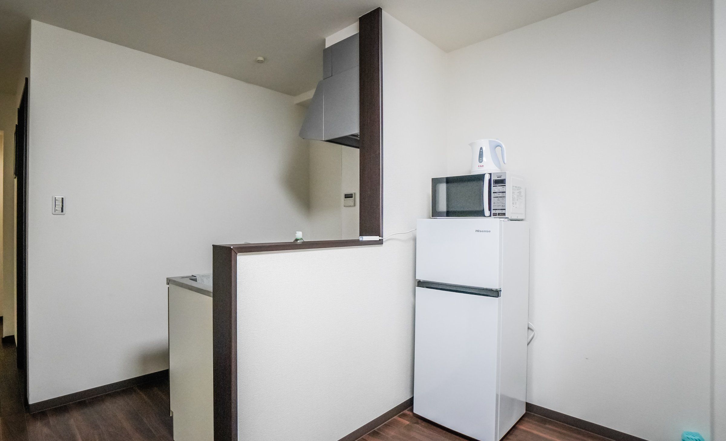 A compact kitchenette with a microwave, a small refrigerator, and a water dispenser.