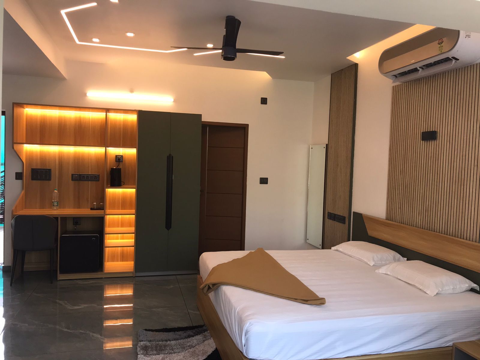 Una habitación de hotel moderna con una cama, un escritorio y un armario.