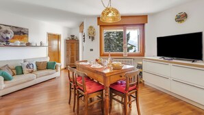 A dining area with a wooden table, chairs, and a television.