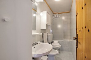 A modern bathroom with a sink, toilet, and shower area.