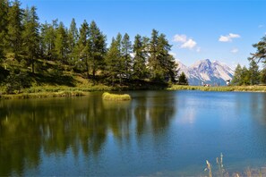 A calm lake surrounded by trees and mountains. - Appartamento Chez Mavi Cond Il Rio for 4, Sauze d'Oulx, Italy (Sauze d'Oulx)