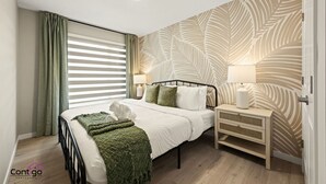 Ein Schlafzimmer mit Bett, Nachttischen, einem Fenster mit Jalousien und einer Wand mit Muster.