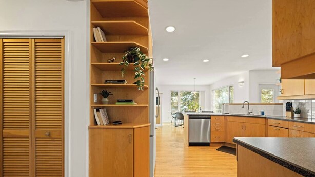 Een moderne keuken met houten kasten, een geïntegreerde vaatwasser en een centraal kookeiland.