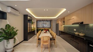 Una cocina moderna con zona de comedor, que incluye una mesa larga, sillas y una estufa empotrada.