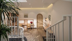 Un interior moderno con una escalera, un espacio de trabajo y una puerta de madera.