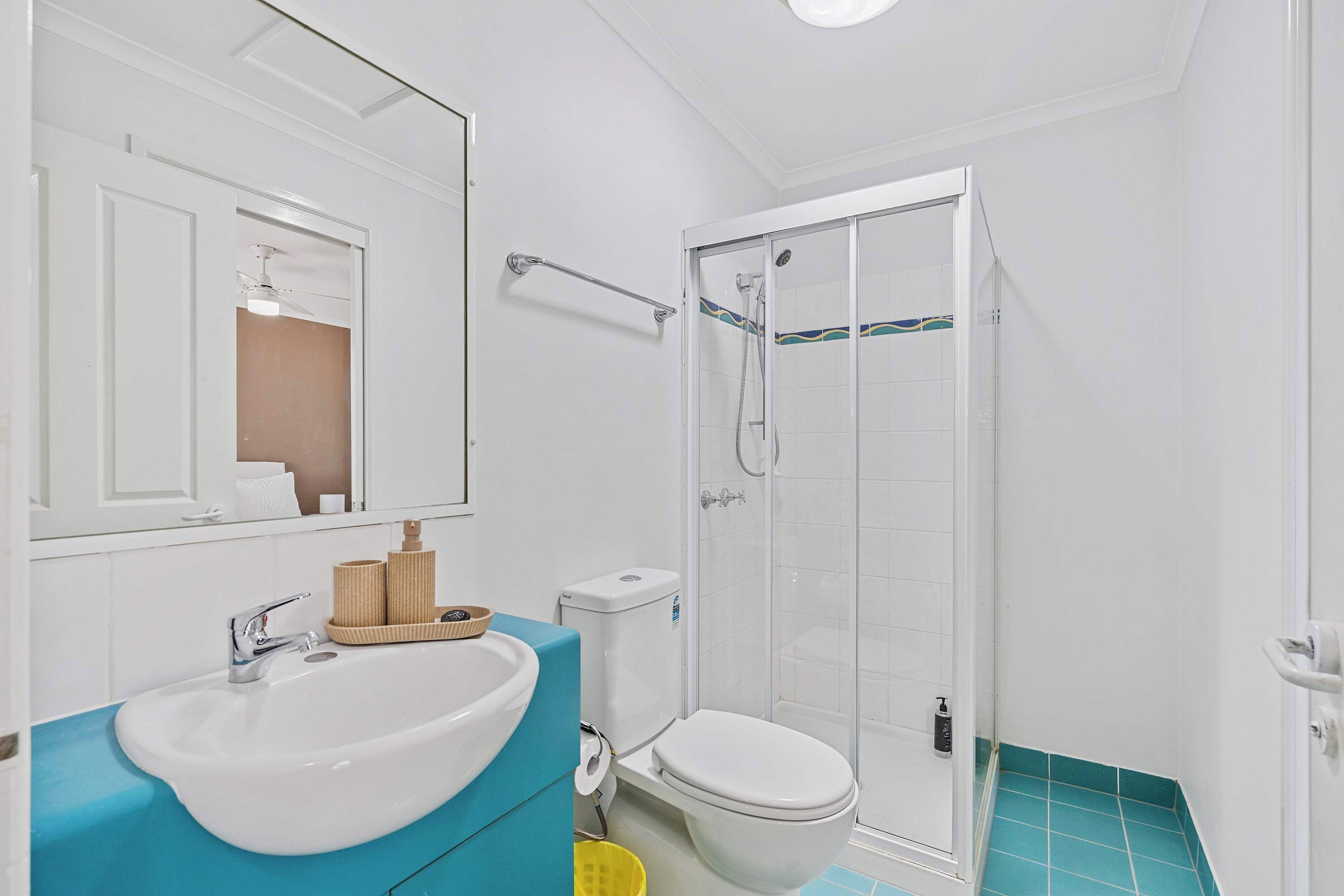A bathroom with a white sink, a toilet, and a glass-enclosed shower.