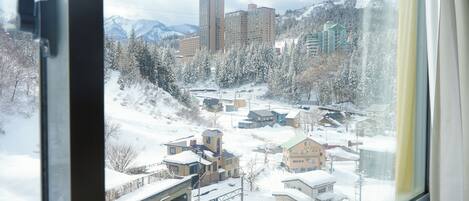 A snowy town with buildings and a mountain backdrop.