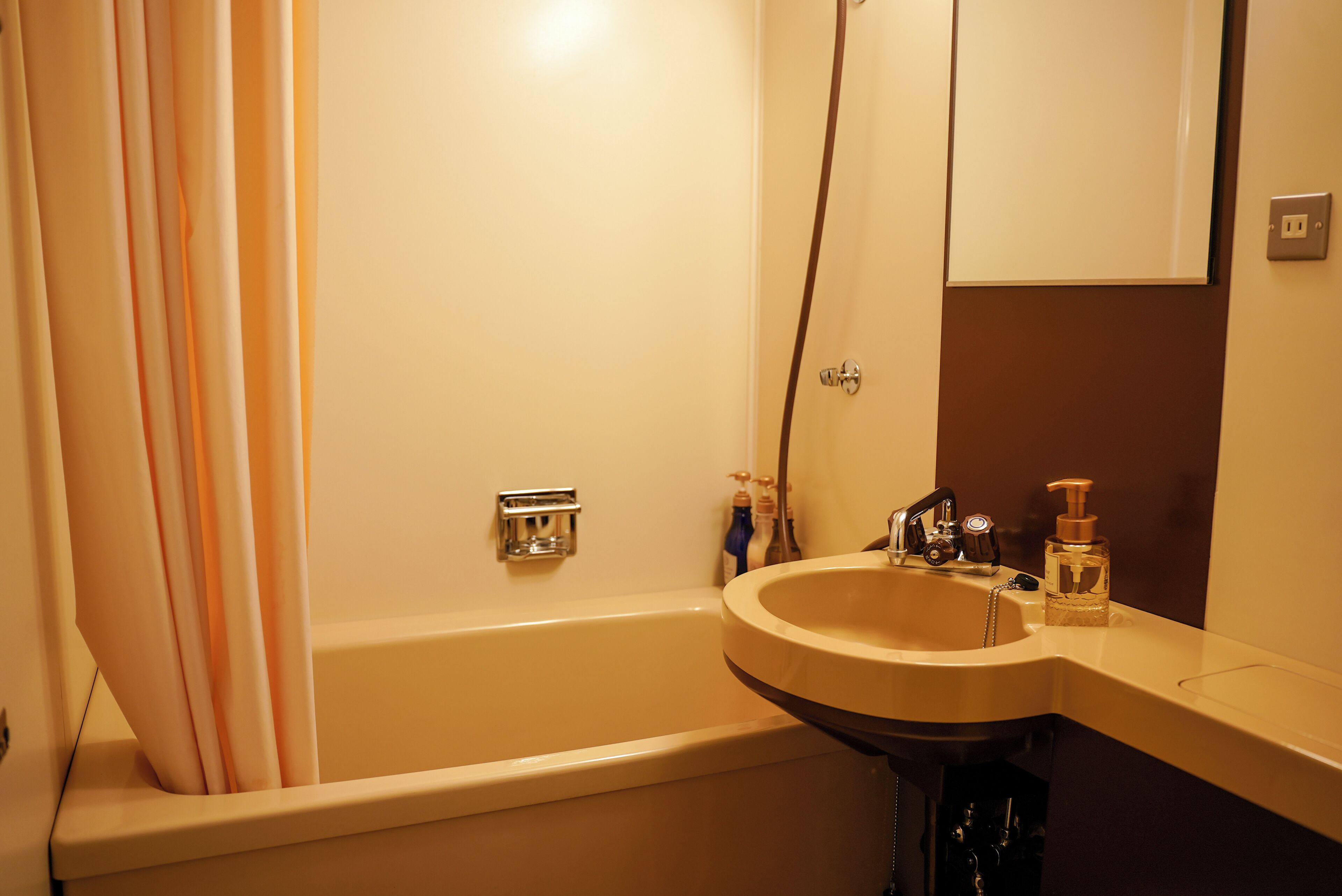 A bathroom with a bathtub, a sink, and a mirror.