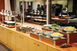 A buffet setup with various food items and serving utensils.