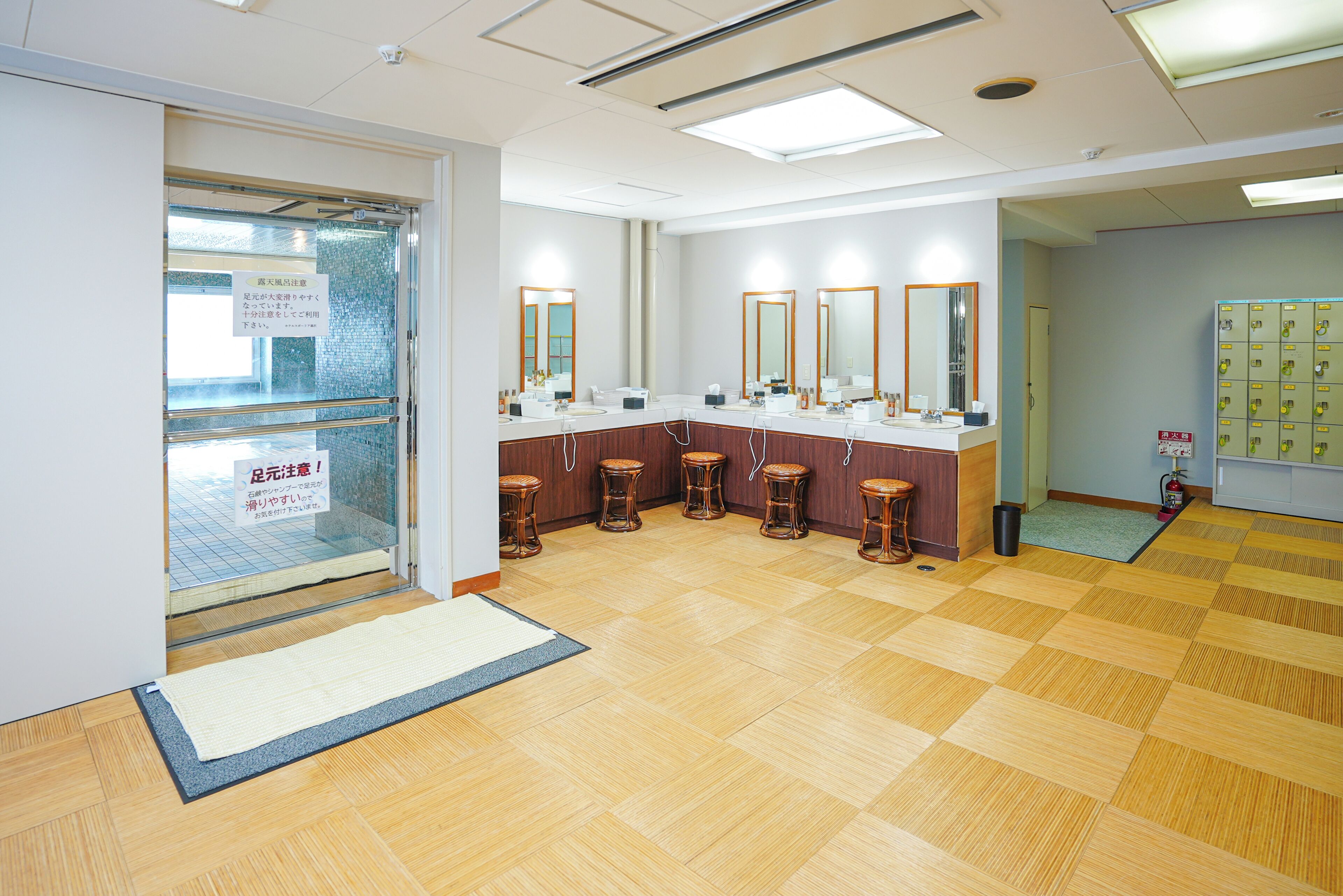 A public restroom with multiple sinks, mirrors, and stools.