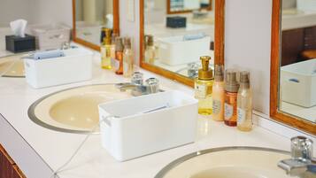A bathroom with two sinks, a mirror, and various toiletries.