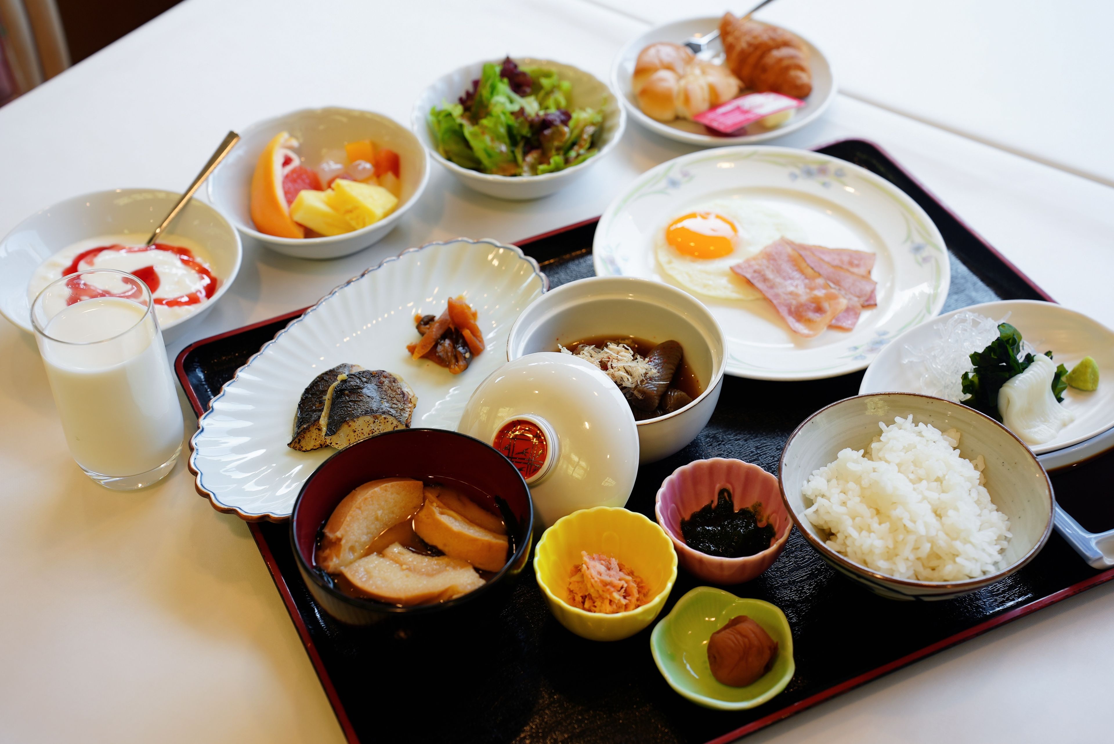 A tray with various dishes including rice, eggs, and a bowl of soup.
