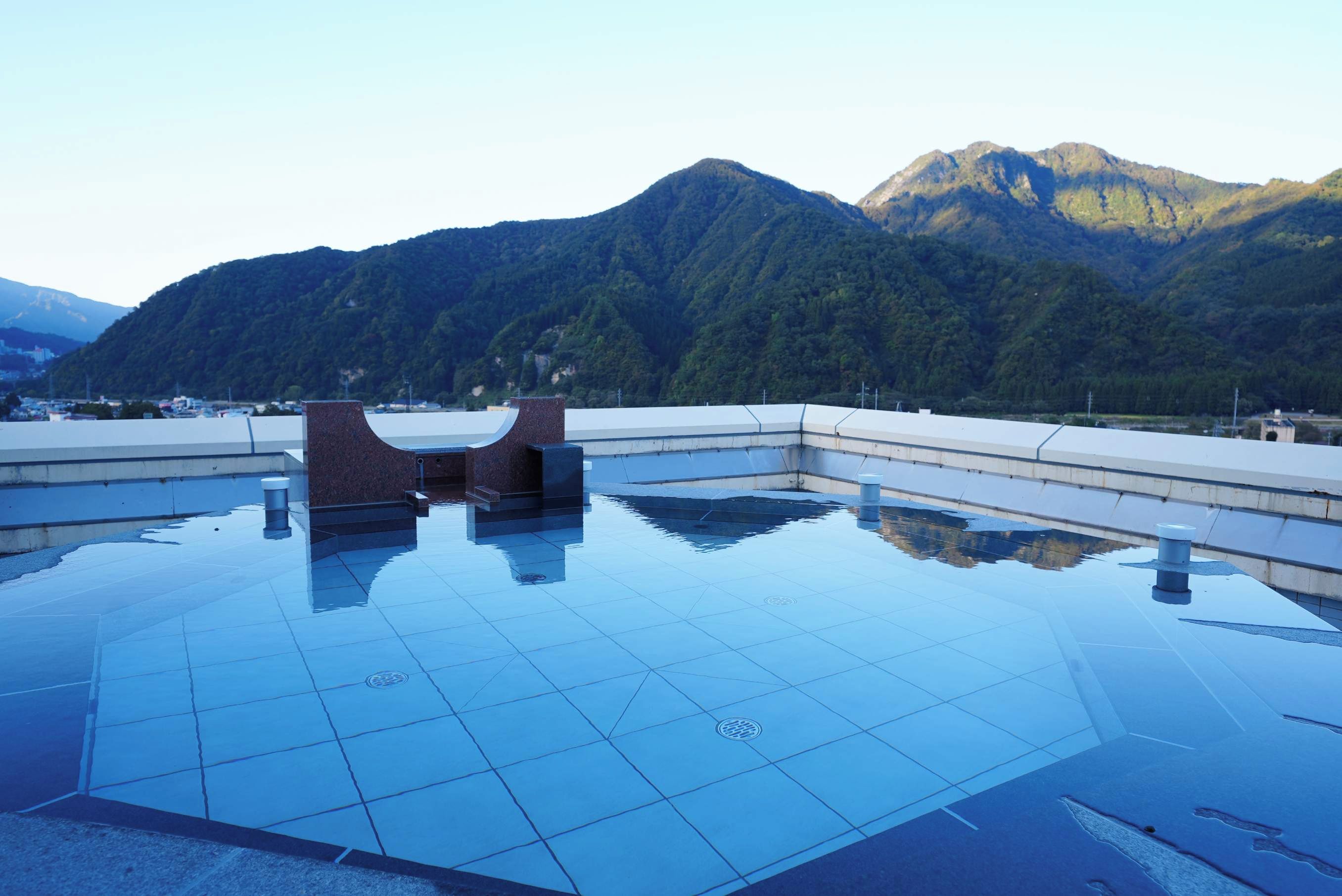 Una piscina en la azotea con vistas a las montañas.
