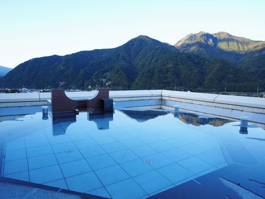 A rooftop pool with a view of mountains.