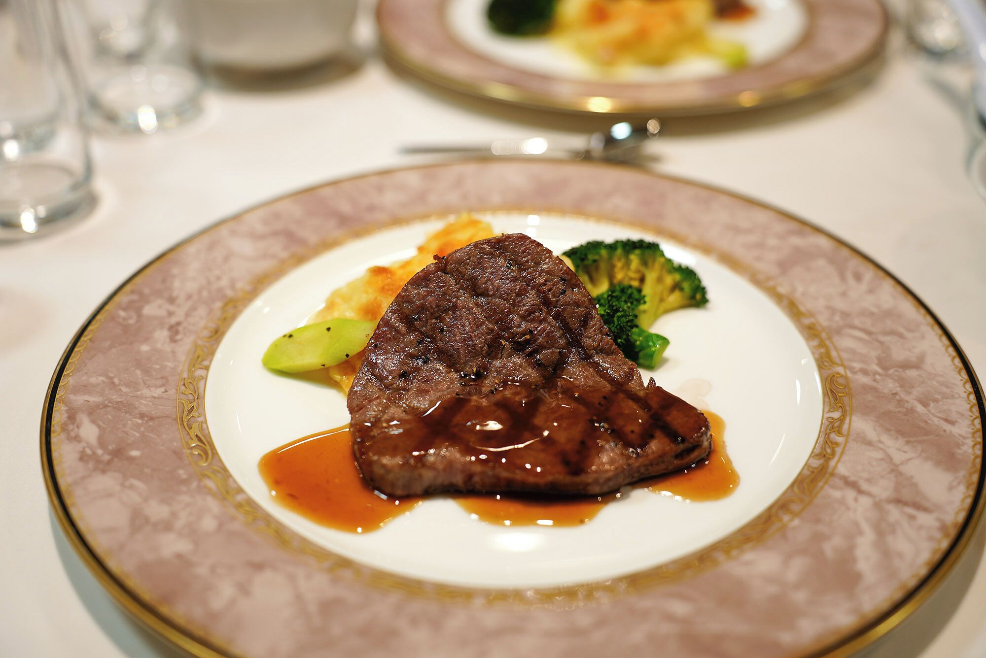 Ein Teller mit einem Steak, Gemüse und Soße.