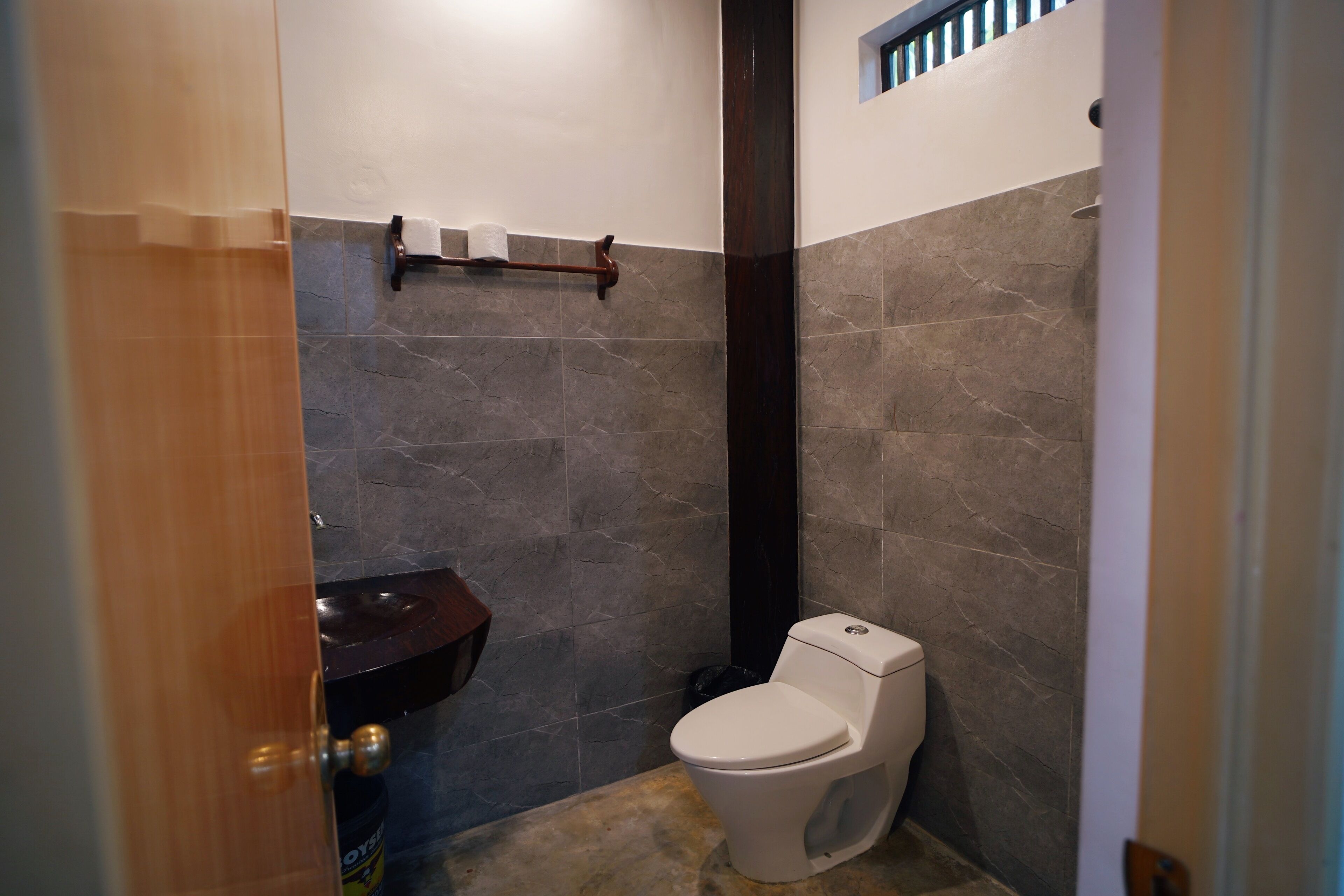 Une salle de bain équipée de toilettes, d’un lavabo et d’un porte-serviettes.