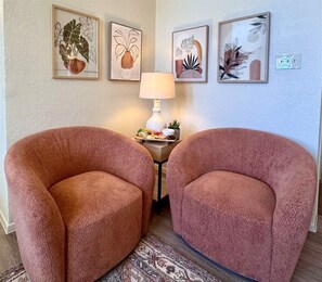 A room with two armchairs, a small table with a lamp, and three framed artworks on the wall. - Baylor House Stylish Abilene Getaway (Abilene)