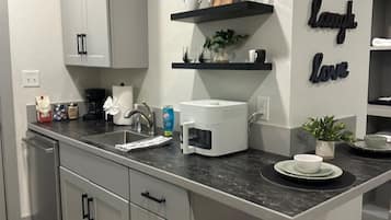A modern kitchen with a central island, white cabinetry, and decorative wall art.