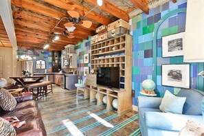 A cozy living room with a wooden ceiling, a sofa, a television, and a bookshelf. - The Dance Hall - Sayles Ranch (Abilene)