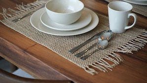 A wooden table with a white bowl and mug set on a woven placemat. - Moraira 1BR Pool Villa Close to Bingin Beach (Pecatu)