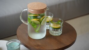 A clear glass pitcher with a cork stopper, filled with mint leaves and lemon slices, placed on a wooden table. - Moraira 1BR Pool Villa Close to Bingin Beach (Pecatu)