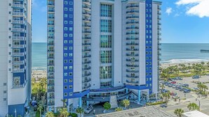 A high-rise hotel with multiple balconies, a pool area, and a beach view. - Oceanfront 2BR Retreat | 17th Floor + Balconies (Myrtle Beach)