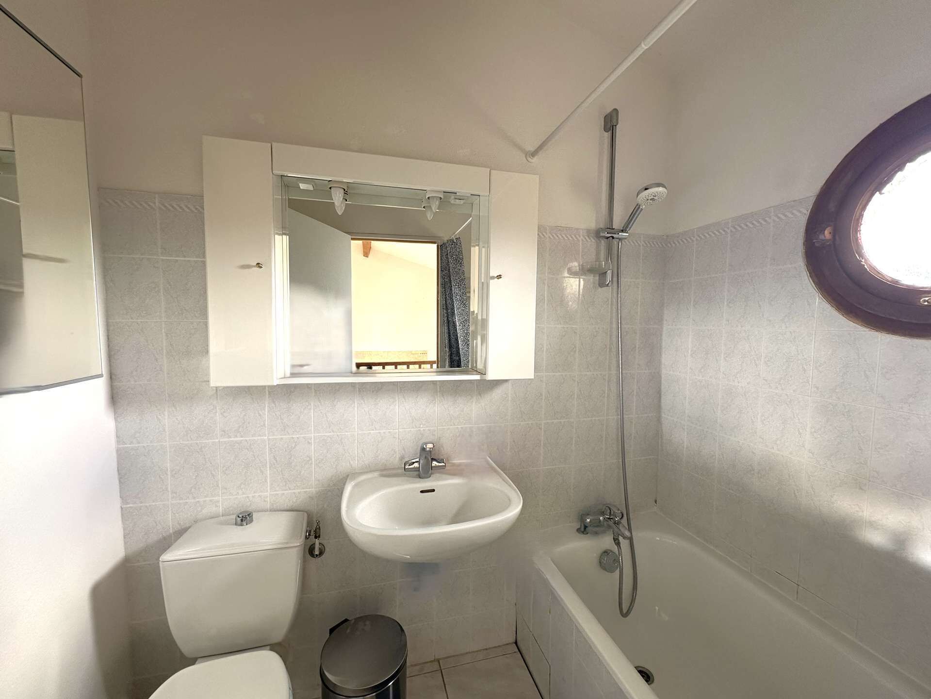A bathroom with a toilet, sink, and bathtub.