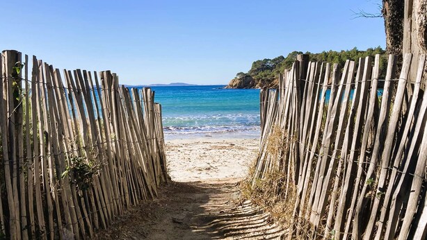 A wooden pathway leading to a beach with clear blue water and a distant view of a mountainous coastline. - House for 6 people near the Valcros Golf Course in La Londe-les-Maures (LA LONDE LES MAURES)