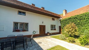 A two-story house with a paved patio, outdoor seating, and a garden wall. - Forrest Haven Vodice by Interhome (Vodice)