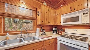 A kitchen with wooden cabinets, a stainless steel sink, a microwave, and a stove. - Mountain Heaven - Hot Tub - Pet Friendly - Long Range Mountain Views - Fire Pit (Blue Ridge)