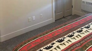 A room with a flat-screen TV mounted on the wall, a double door closet, and a patterned carpet. - On The Banks Of The Salon River 2 Bed/2 Bath/Sleeps 6 (Salmon)