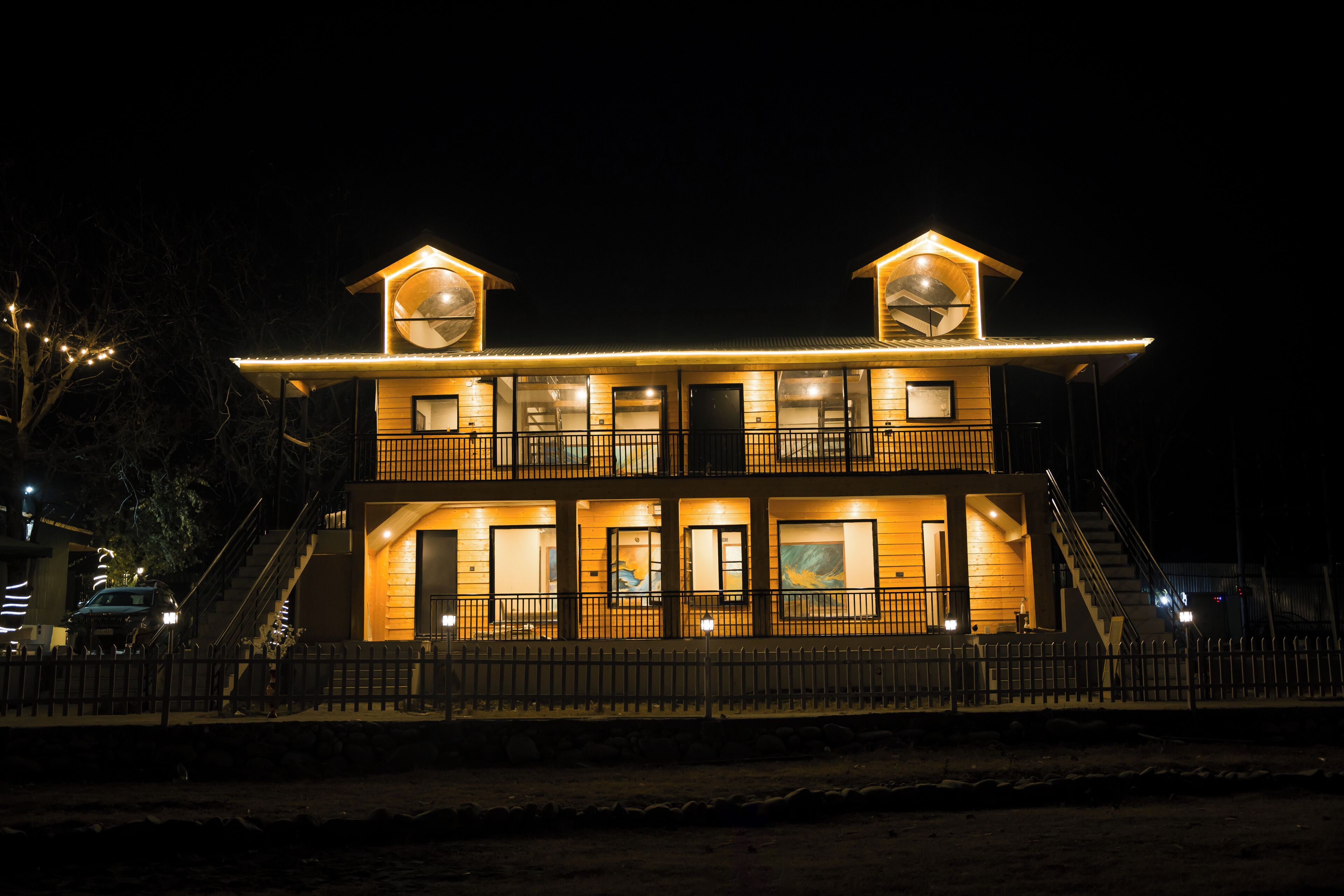 A two-story building with a balcony, a staircase, and a fence.