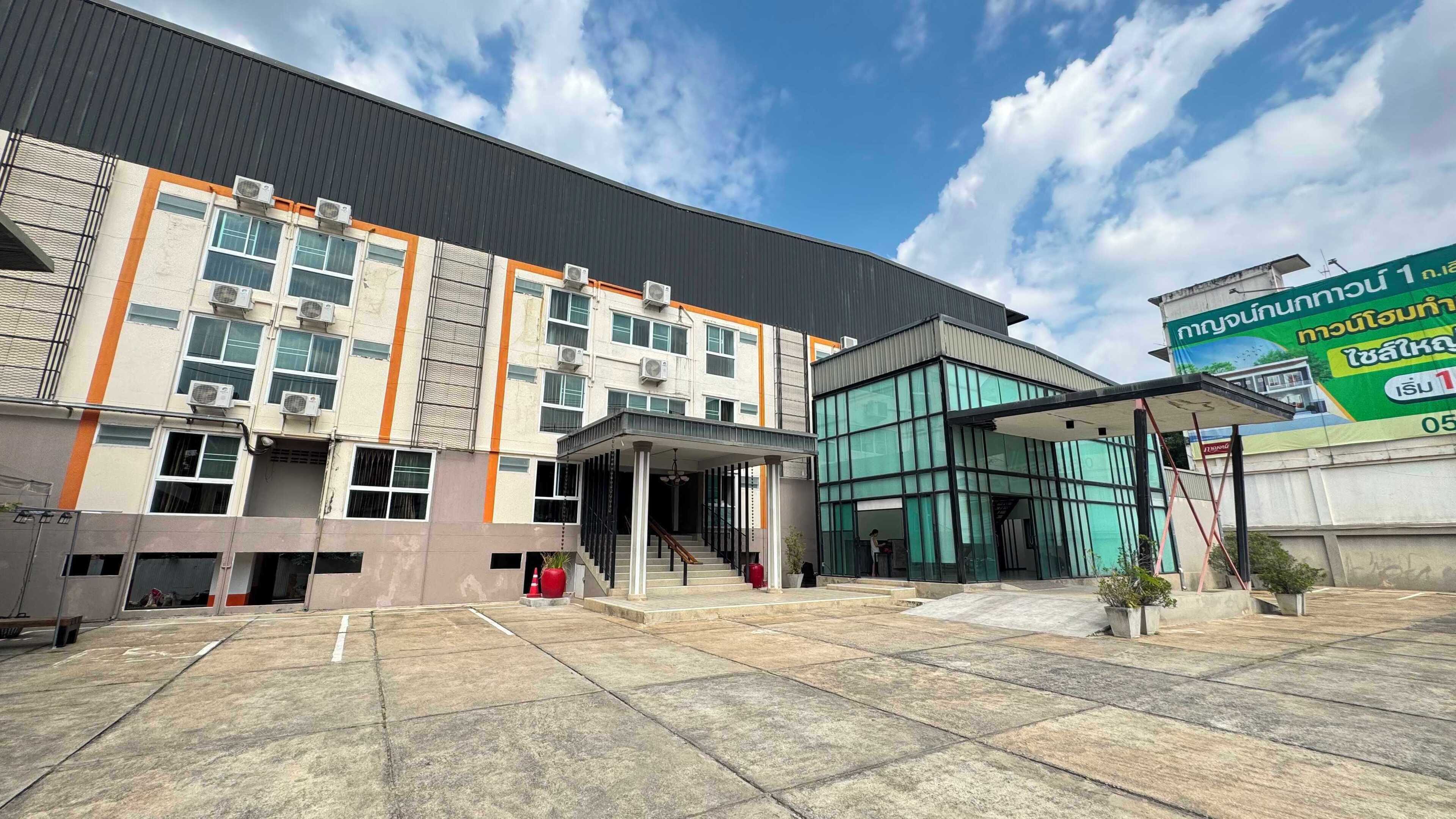 A multi-story building with a covered entrance and a glass facade.