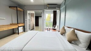 Una habitación de hotel moderna con una cama grande, un escritorio de madera y vistas al exterior.