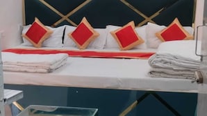 Een hotelkamer met een bed, een groene bank en een kleine tafel.